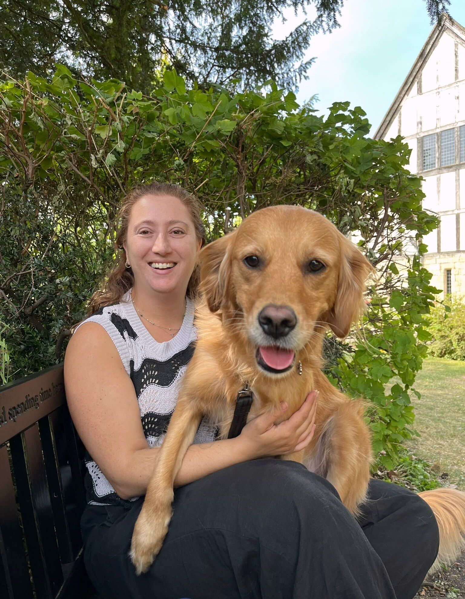 Tamara sitting on a bench with Skye, her golden retriever, on her lap